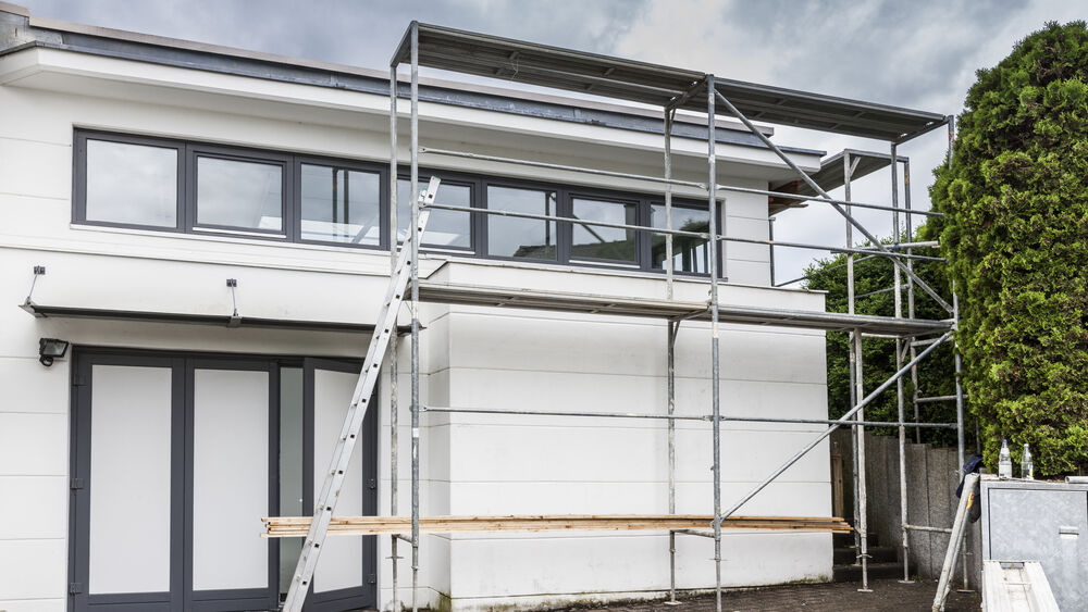 A new house with scaffolding at the front of the house.